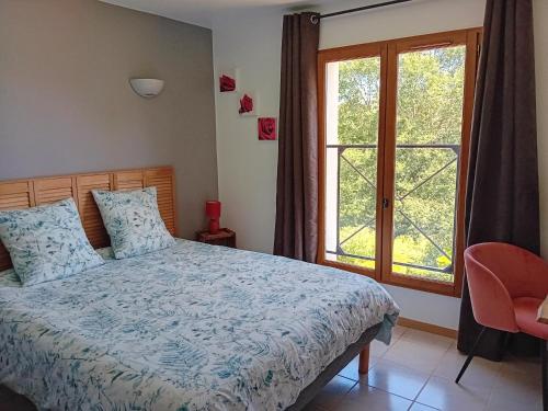 ein Schlafzimmer mit einem Bett und einem Fenster in der Unterkunft Chambres d'hôtes Le Pygargue in Sarlat-la-Canéda