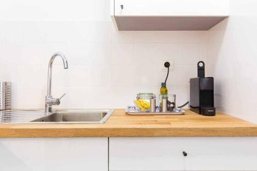 a kitchen counter with a sink and a microwave at Gem of Alfama in Lisbon