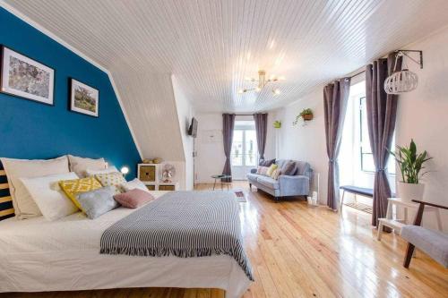 a bedroom with a large bed and a blue wall at Gem of Alfama in Lisbon