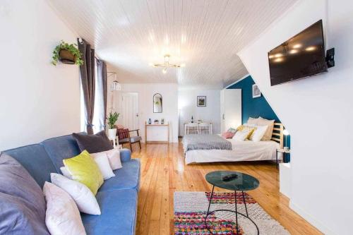 a living room with a blue couch and a bed at Gem of Alfama in Lisbon
