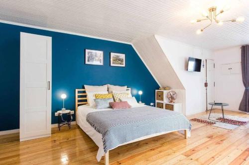 a bedroom with a large bed with a blue wall at Gem of Alfama in Lisbon