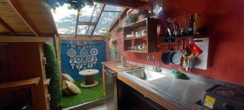 a kitchen with a sink in a tiny house at Bohemio Chic House - Alojamiento con vista al bosque a 45 minutos de Medellin en Santa Elena in Santa Elena