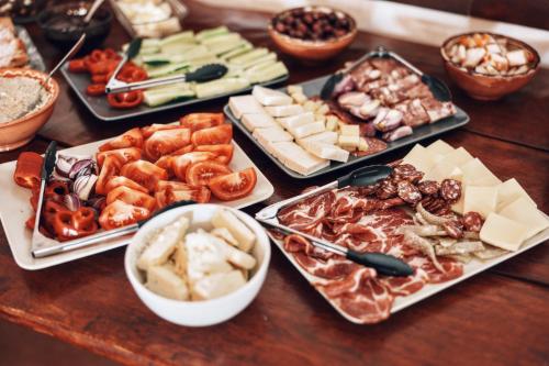 ein Tisch mit einer Reihe von verschiedenen Arten von Lebensmitteln in der Unterkunft Pensiunea Fântâniţa Haiducului in Ciungetu