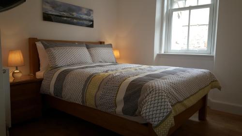 a bed in a bedroom with a window at Tighnabruaich Annex in Lossiemouth