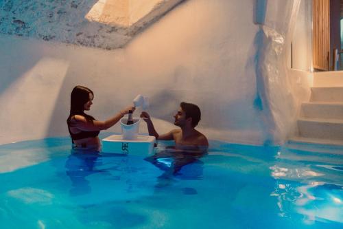 a man and a woman in the water at Regina Elena Suites & Private SPA in Sannicola