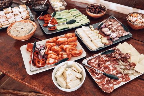 ein Tisch mit vielen verschiedenen Arten von Essen darauf in der Unterkunft Pensiunea Fântâniţa Haiducului in Ciungetu