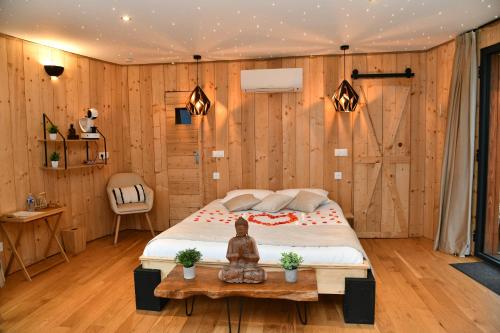 a bedroom with a bed in a wooden wall at Domaine des Étoiles - Logements Insolites in Gillonnay