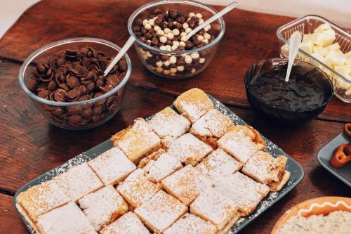 Ein Holztisch, gedeckt mit Desserts und Schalen mit Nüssen in der Unterkunft Pensiunea Fântâniţa Haiducului in Ciungetu