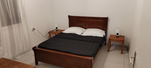 a bedroom with a bed with two night stands and two lamps at T3 Parenthèse des Plaines in La Plaine des Palmistes