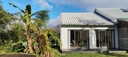 a small house with white walls and windows at T3 Parenthèse des Plaines in La Plaine des Palmistes