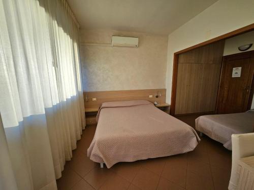 a hotel room with two beds and a window at Albergo Nyers in Perugia