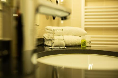 a bathroom with a sink and towels on a counter at Ringhotel Appelbaum Gütersloh in Gütersloh