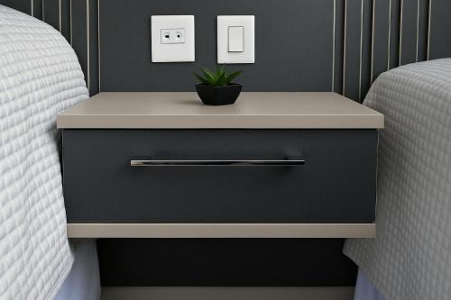 - une table de chevet à côté d'un lit avec une plante dans l'établissement Suíte Privilegiada no Centro - Golden Dolphin, à Caldas Novas