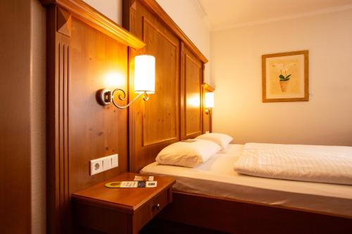 a hotel room with two beds and a table at Ringhotel Appelbaum Gütersloh in Gütersloh