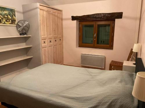 a bedroom with a bed and a window at Le Garn in Le Garn