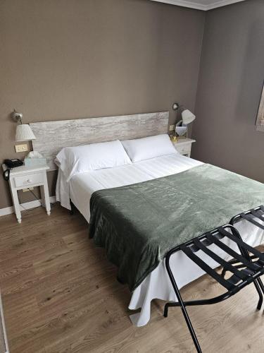 a bedroom with a large bed with a green blanket at Hotel Colegiata in Santillana del Mar