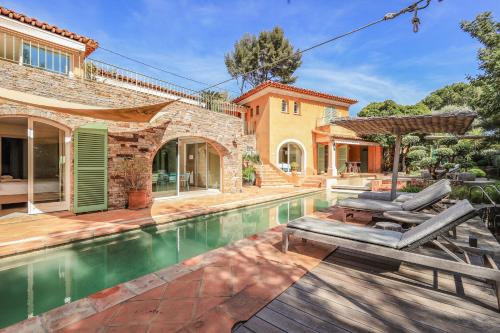 une maison avec une piscine dans une cour dans l'établissement VILLA LES PINS, au Lavandou