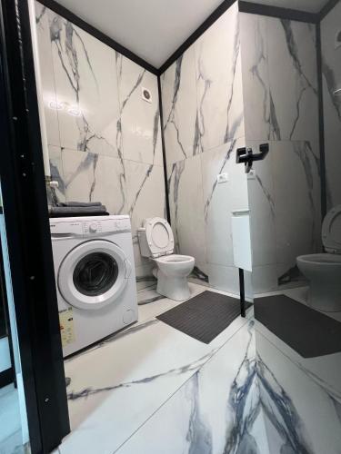 a bathroom with a washing machine and a toilet at Garsoniera Zona Stadion in Craiova