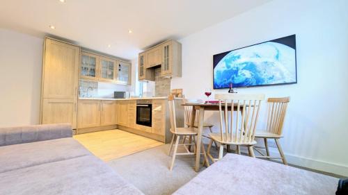 a kitchen and dining room with a table and chairs at Dunes Apartment by Seaside Llandudno in Llandudno