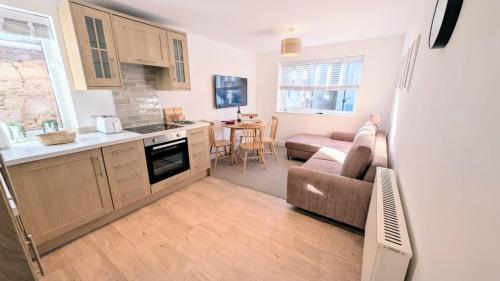 a kitchen and living room with a couch and a table at Dunes Apartment by Seaside Llandudno in Llandudno