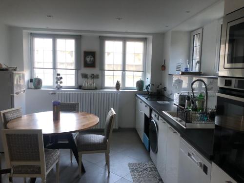 une cuisine avec une table et un évier et une table et des chaises dans l'établissement La montagnarde, à Huelgoat