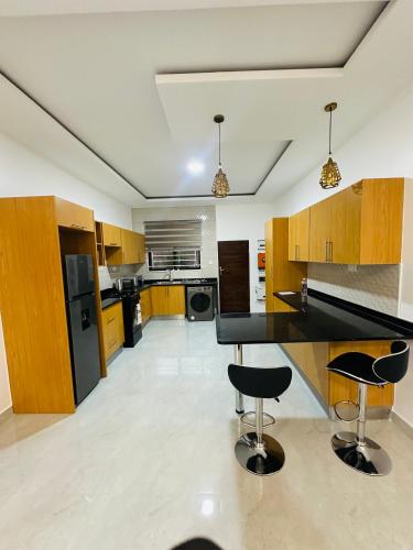 a kitchen with a black counter and two bar stools at Silverest Place in Lusaka