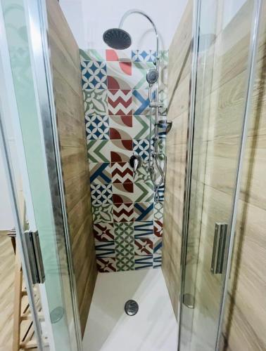 a shower with a mosaic wall in a bathroom at Casa Fedele in Trani