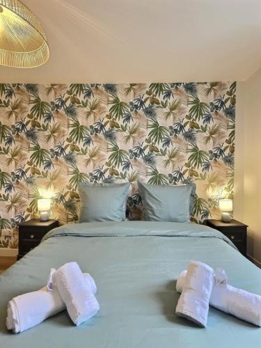 une chambre avec un lit avec deux serviettes dessus dans l'établissement Doux Murmures, appartement 73m2 calme et élegant, 2 chambres, à Mâcon