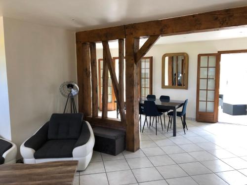 un salon avec un canapé et une table avec des chaises dans l'établissement Ma belle Normande entre terre et mer - My beautiful Normandy, between land and sea, à Saint-Léonard