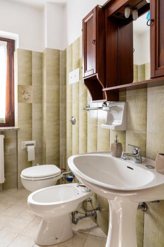 a bathroom with a white sink and a toilet at Mountain Paradise Panoramic View in Madonna della Costa