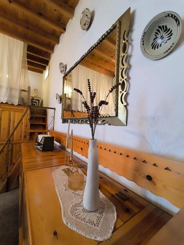 a vase on a wooden table with a mirror at Rustic House Archangelos in Archangelos