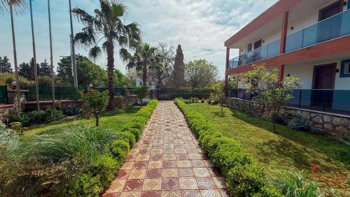 a walkway in front of a building with palm trees at Çınar Butik Hotel Bodrum in Bodrum City