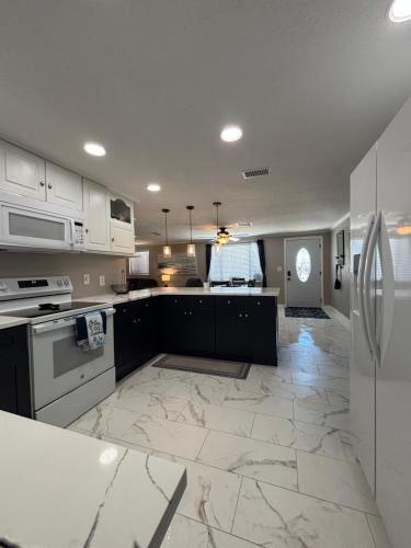 a large kitchen with white cabinets and appliances at Gorgeous Seaside Seashell Cottage! in Hudson