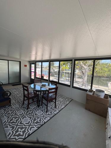 a room with a table and chairs and windows at Gorgeous Seaside Seashell Cottage! in Hudson