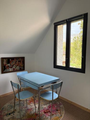 une table bleue et deux chaises dans une pièce dans l'établissement Studio Fourchaume, à Chablis