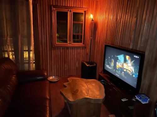 a living room with a couch and a flat screen tv at Kribi-Lodge in Kribi