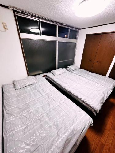 東京にあるShinjuku East Sunny Houseのベッドルーム1室(ベッド2台、クローゼット付)