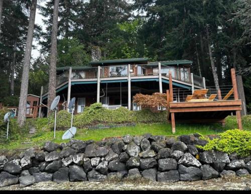 a large house with a deck in the woods at Hammersley Inlet- Oyster beach, Relaxing Views in Shelton