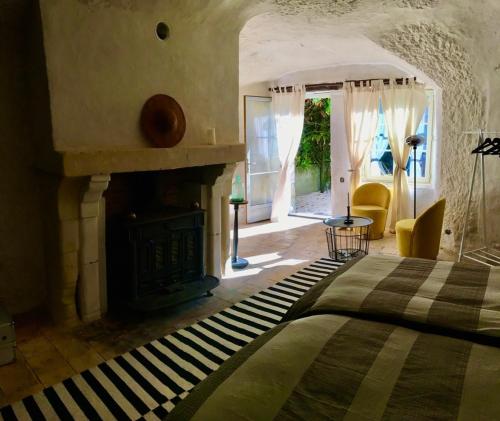une chambre avec un lit et une cheminée dans l'établissement Charming troglodyte near Amboise, à Pocé-sur-Cisse