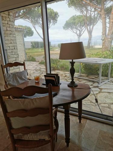 une table avec une lampe, une chaise et une fenêtre dans l'établissement Sea-facing villa in La Flotte-en-Ré, à La Flotte