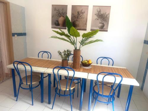 a dining room table with chairs and a potted plant at Villa Paradisos Archangelos in Archangelos