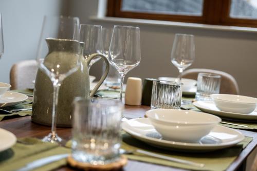 a table with glasses and plates and bowls on it at Grovefield Getaway in Belfast