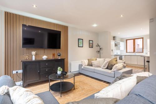 a living room with a couch and a tv at Grovefield Getaway in Belfast