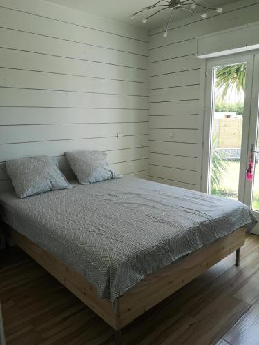 une chambre avec un lit dans une pièce avec une fenêtre dans l'établissement Maison en bois atypique, à Audenge