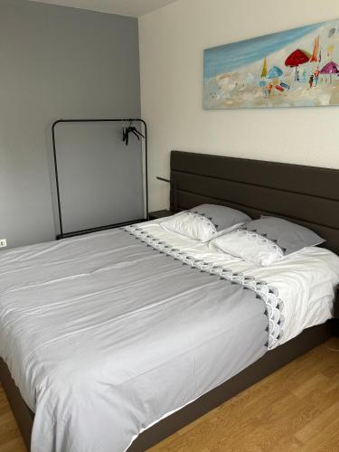 une chambre avec un grand lit avec des draps blancs dans l'établissement Solidor, à Saint-Malo