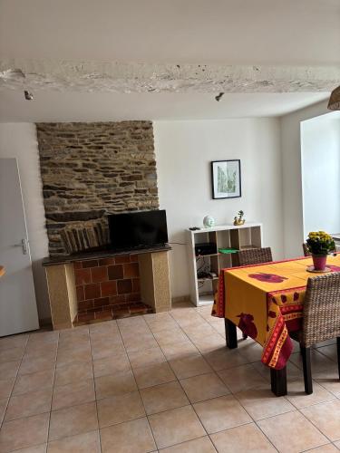 un salon avec une table et un mur en pierre dans l'établissement Solidor, à Saint-Malo