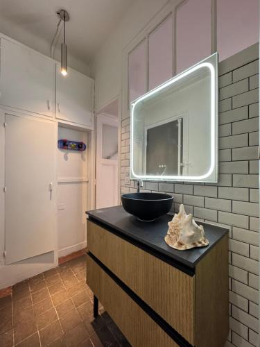 une salle de bain avec un lavabo et un miroir dans l'établissement Studio cosy Paris 15, à Paris