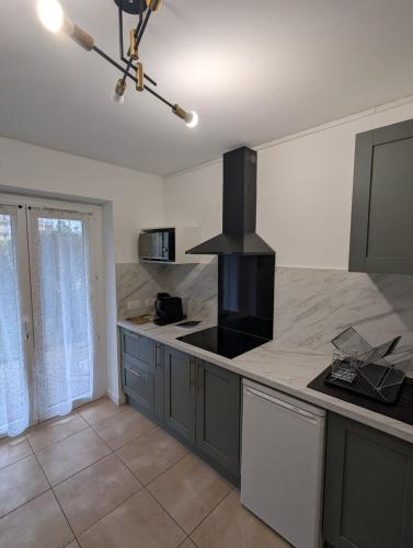 une cuisine avec une cuisinière et un comptoir dans l'établissement Confortable et moderne avec clim et jardin privé - Appartement Sauge, à Thonon-les-Bains