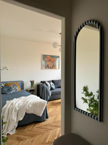 a bedroom with a mirror and a bed and a couch at Apartament Lady Eleven in Gdańsk