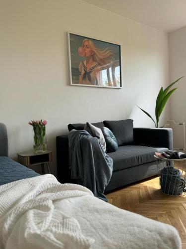 a living room with a couch and a painting on the wall at Apartament Lady Eleven in Gdańsk